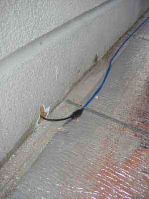 Греющий кабель Теплолюкс‑Elite проходит через стену в комнату к терморегулятору